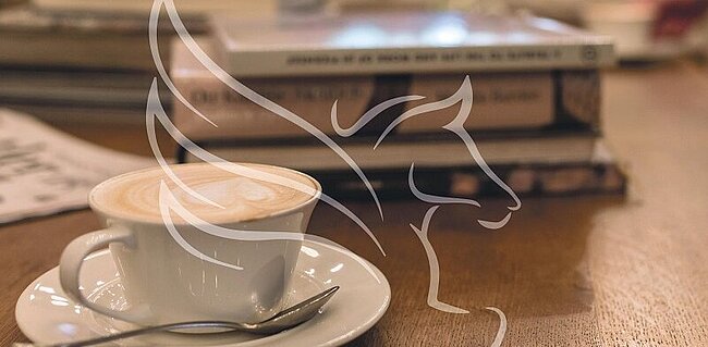 Tasse Kaffee auf einem Tisch mit Büchern